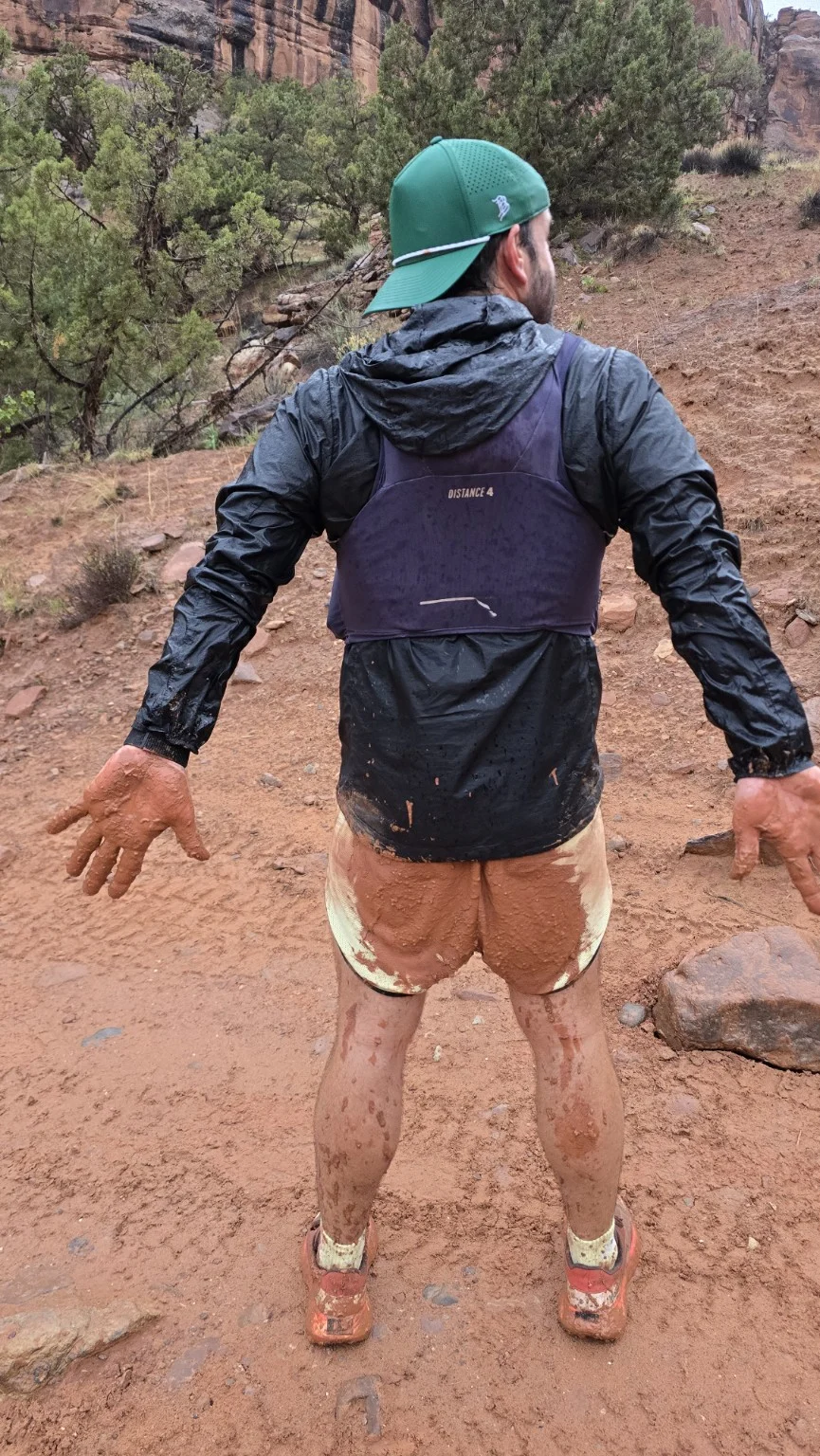 A runner standing on a sandy desert trail